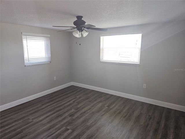 spare room featuring a textured ceiling, dark wood-style floors, a ceiling fan, and baseboards