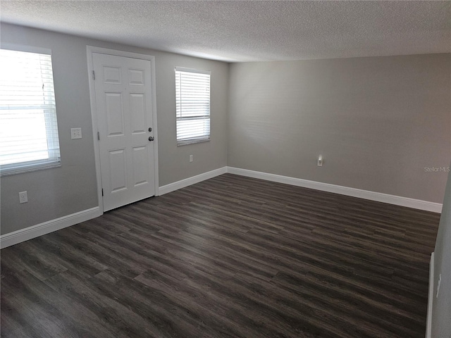 entryway featuring dark wood-style flooring, a textured ceiling, and baseboards