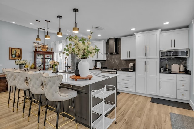 332 Wood Dove Ave, Tarpon Springs, FL 34689 - kitchen with wall chimney exhaust hood, a sink, tasteful backsplash, a breakfast bar, and recessed lighting