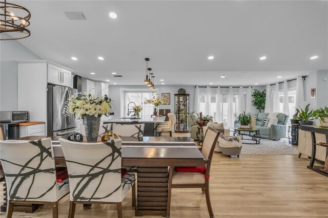 332 Wood Dove Ave, Tarpon Springs, FL 34689 - dining space with light wood-style flooring, recessed lighting, and a chandelier