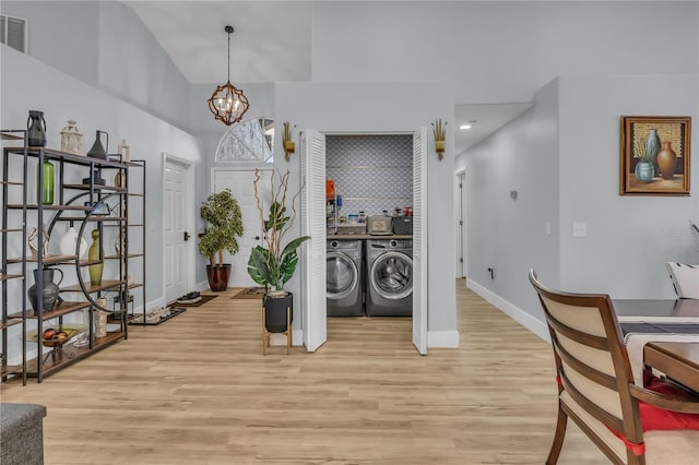 332 Wood Dove Ave, Tarpon Springs, FL 34689 - clothes washing area featuring independent washer and dryer, light wood-style floors, baseboards, a chandelier, and a towering ceiling