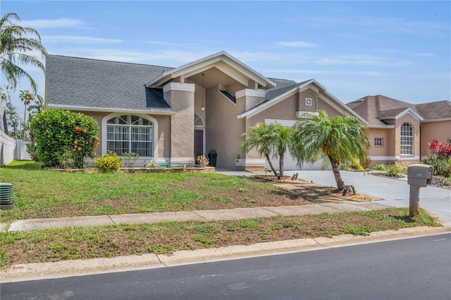 332 Wood Dove Ave, Tarpon Springs, FL 34689 - view of front of property featuring stucco siding, driveway, a shingled roof, central AC, and an attached garage