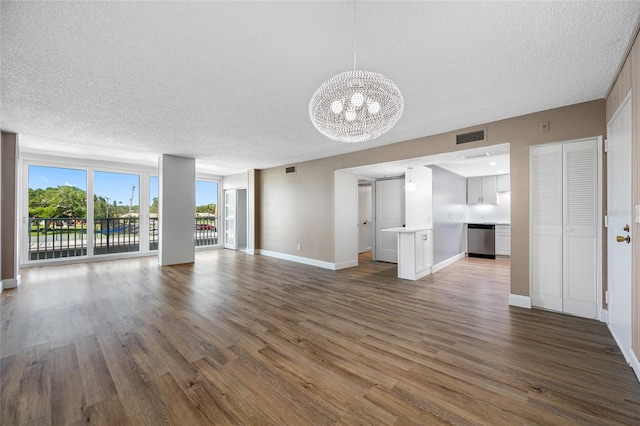 10216 Regal Dr Unit 208, Largo, FL 33774 - unfurnished living room with a chandelier, a textured ceiling, wood finished floors, and baseboards