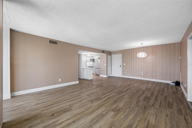 10216 Regal Dr Unit 208, Largo, FL 33774 - unfurnished living room with wood finished floors, a textured ceiling, and baseboards