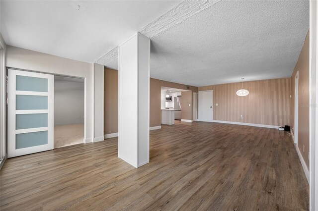 10216 Regal Dr Unit 208, Largo, FL 33774 - unfurnished living room featuring wood finished floors, baseboards, and a textured ceiling