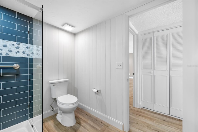 10216 Regal Dr Unit 208, Largo, FL 33774 - full bathroom featuring wood finished floors, toilet, a stall shower, and baseboards
