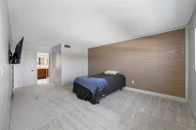 10216 Regal Dr Unit 208, Largo, FL 33774 - bedroom with carpet flooring, baseboards, wooden walls, connected bathroom, and a textured ceiling