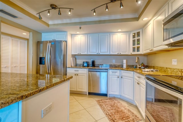 14146 Gulf Blvd Unit 4B, Madeira Beach, FL 33708 - kitchen featuring appliances with stainless steel finishes, crown molding, a raised ceiling, stone countertops, and light tile patterned floors