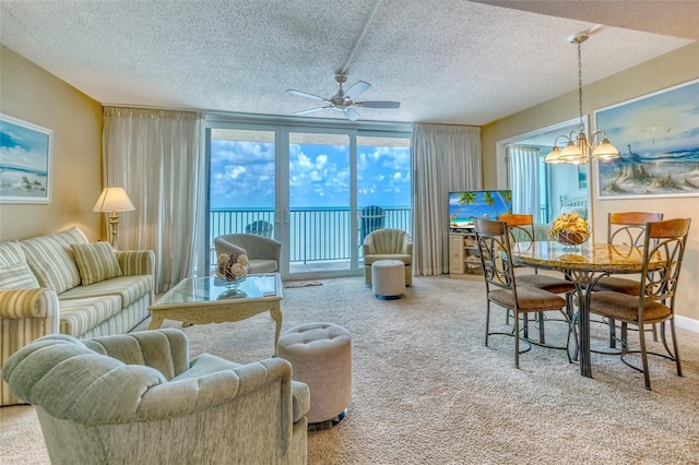 14146 Gulf Blvd Unit 4B, Madeira Beach, FL 33708 - carpeted living room featuring a ceiling fan, a textured ceiling, and a chandelier