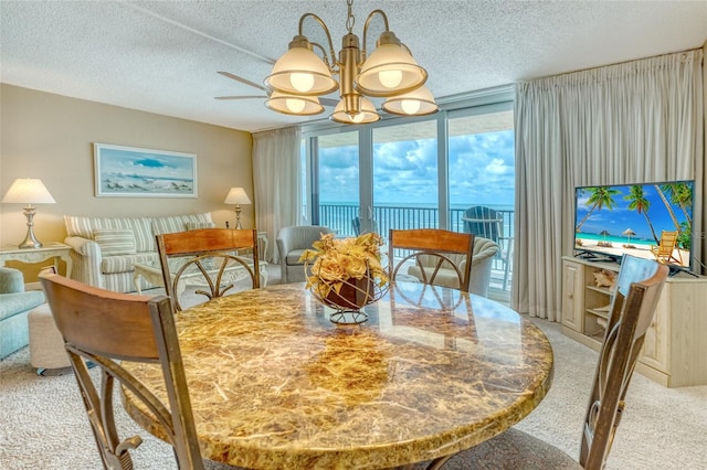 14146 Gulf Blvd Unit 4B, Madeira Beach, FL 33708 - dining room with a chandelier, a textured ceiling, light colored carpet, and expansive windows