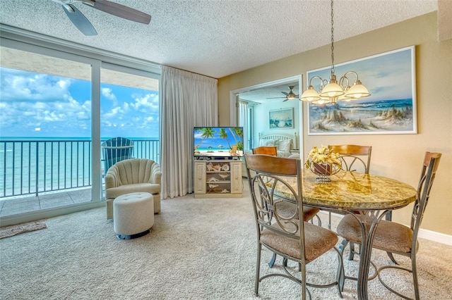 14146 Gulf Blvd Unit 4B, Madeira Beach, FL 33708 - dining area featuring ceiling fan, carpet floors, a textured ceiling, a wall of windows, and a chandelier