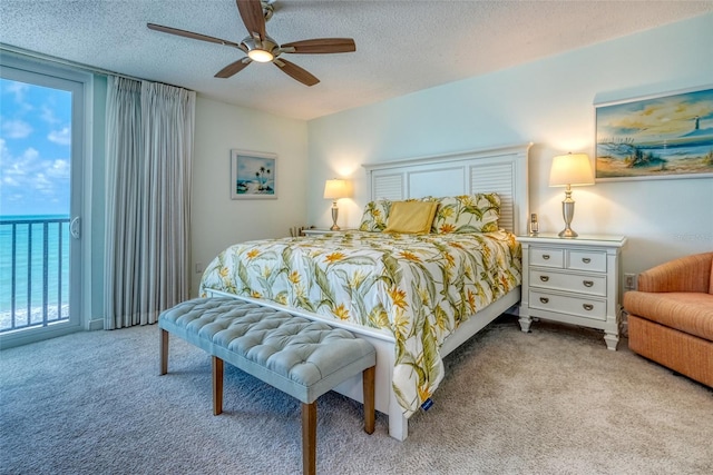 14146 Gulf Blvd Unit 4B, Madeira Beach, FL 33708 - carpeted bedroom featuring access to exterior, a textured ceiling, and ceiling fan