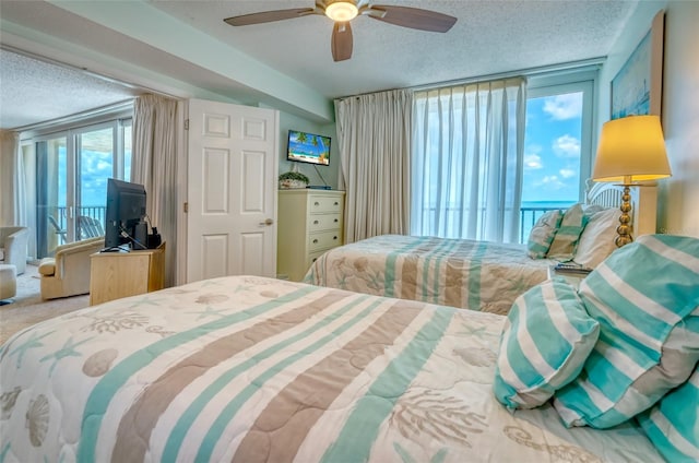 14146 Gulf Blvd Unit 4B, Madeira Beach, FL 33708 - carpeted bedroom featuring a textured ceiling, access to exterior, and ceiling fan
