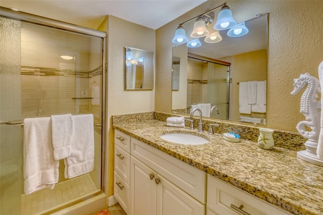 14146 Gulf Blvd Unit 4B, Madeira Beach, FL 33708 - full bathroom featuring a shower stall, vanity, and a textured wall