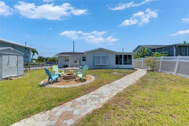 825 Seabreeze Dr, Ruskin, FL 33570 - rear view of house featuring a fire pit, a shed, an outbuilding, and stucco siding