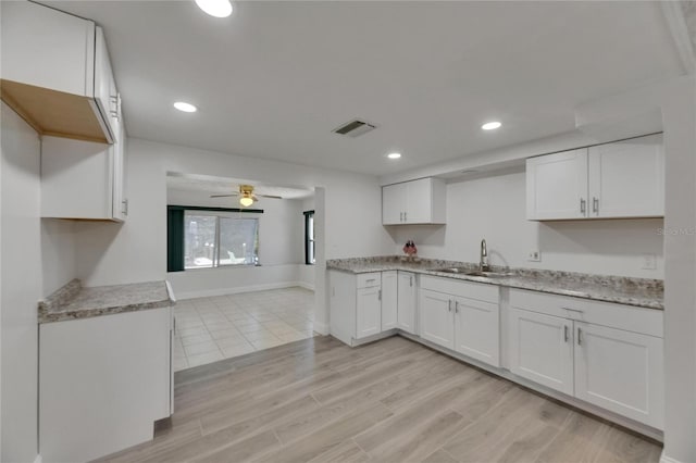825 Seabreeze Dr, Ruskin, FL 33570 - kitchen featuring a sink, white cabinetry, ceiling fan, light wood finished floors, and recessed lighting