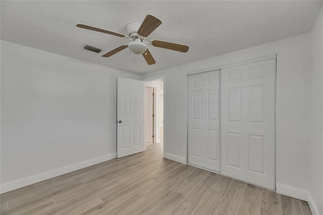 825 Seabreeze Dr, Ruskin, FL 33570 - unfurnished bedroom with light wood-style flooring, baseboards, a closet, and a ceiling fan