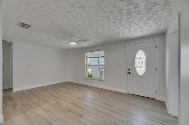 825 Seabreeze Dr, Ruskin, FL 33570 - foyer with a ceiling fan, plenty of natural light, light wood-type flooring, and a textured ceiling