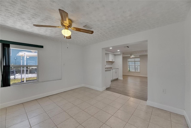 825 Seabreeze Dr, Ruskin, FL 33570 - unfurnished room with a ceiling fan, a textured ceiling, baseboards, and light tile patterned floors