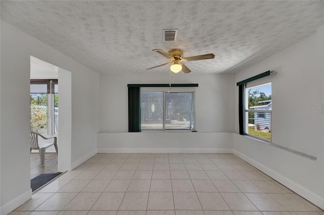 825 Seabreeze Dr, Ruskin, FL 33570 - empty room with a ceiling fan, a textured ceiling, light tile patterned floors, and baseboards
