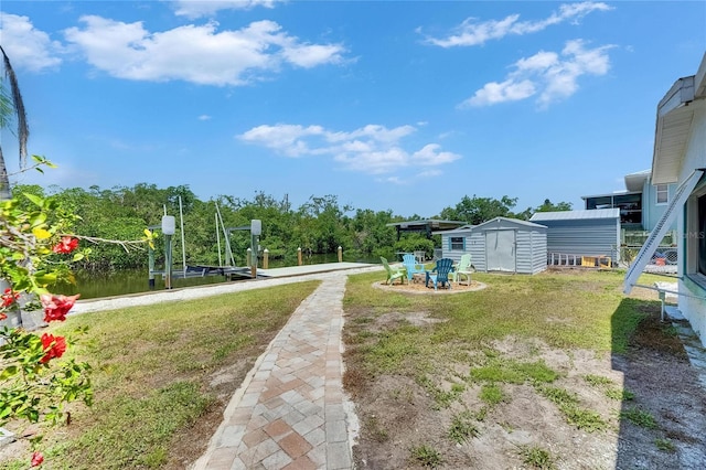 825 Seabreeze Dr, Ruskin, FL 33570 - view of green lawn featuring a storage unit, an outbuilding, boat lift, and a boat dock