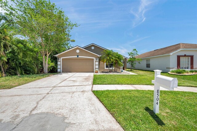 8504 Tidal Bay Ln, Tampa, FL 33635 - view of front of home with a front yard, concrete driveway, a garage, and stucco siding