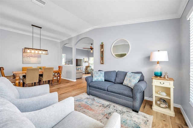 8504 Tidal Bay Ln, Tampa, FL 33635 - living room with crown molding, baseboards, light wood-type flooring, arched walkways, and ceiling fan