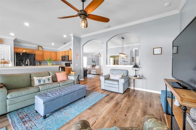 8504 Tidal Bay Ln, Tampa, FL 33635 - living room featuring arched walkways, ceiling fan, crown molding, light wood-style floors, and recessed lighting