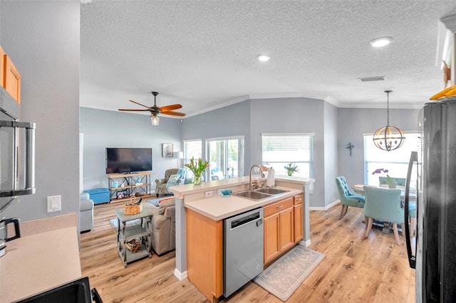 8504 Tidal Bay Ln, Tampa, FL 33635 - kitchen with stainless steel dishwasher, a sink, crown molding, a textured ceiling, and light wood-type flooring