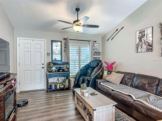 living area featuring ceiling fan, wood finished floors, and a textured ceiling
