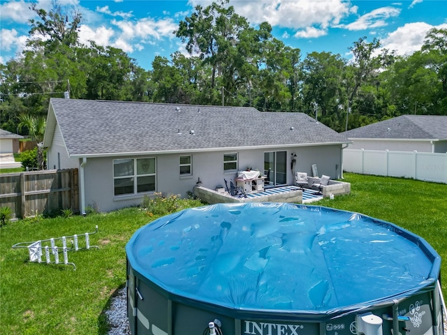 back of property with stucco siding, roof with shingles, and a jacuzzi