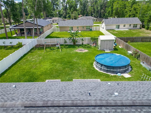 view of yard with a storage shed, an outbuilding, and a residential view