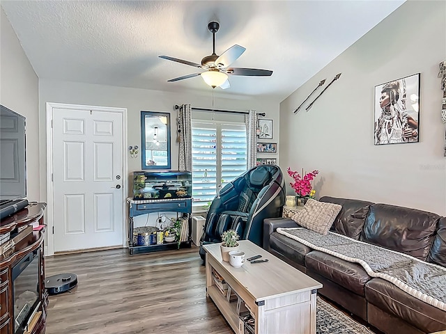living area with a ceiling fan, wood finished floors, and a textured ceiling
