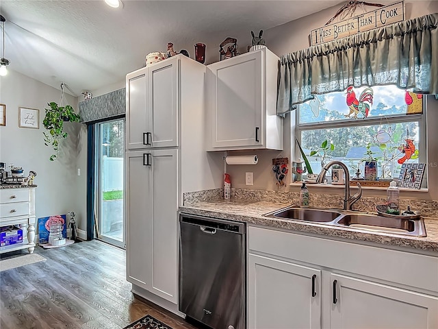 kitchen featuring stainless steel dishwasher, a sink, vaulted ceiling, dark wood-style flooring, and white cabinetry