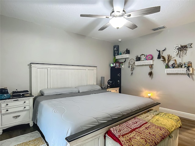 bedroom featuring dark wood-type flooring, a ceiling fan, and baseboards