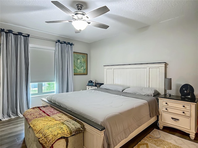 bedroom with dark wood-style floors, a ceiling fan, and a textured ceiling