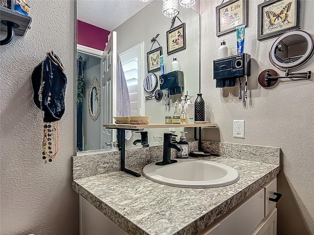 bathroom with vanity and a textured wall