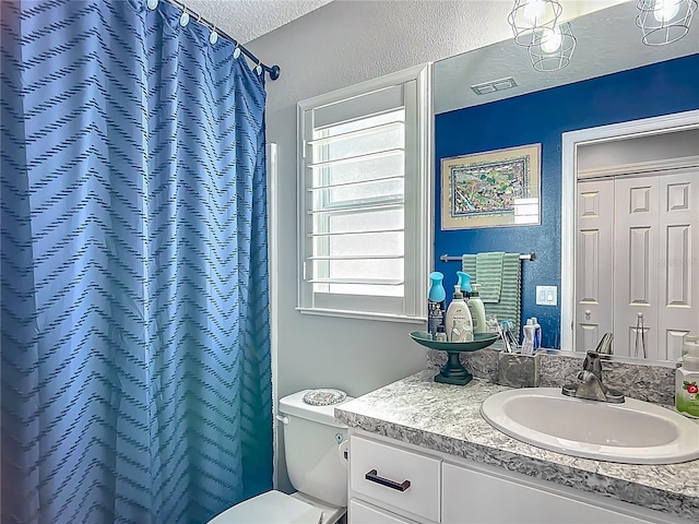 full bath with a textured ceiling, vanity, toilet, and a shower with curtain