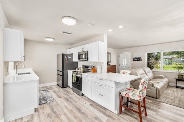 1530 Picardy Cir, Clearwater, FL 33755 - kitchen with stainless steel appliances, open floor plan, light countertops, light wood-style flooring, and recessed lighting