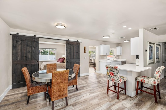 1530 Picardy Cir, Clearwater, FL 33755 - dining area with a barn door, light wood-style floors, and recessed lighting