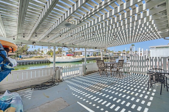 28 Seaside Ct, Holmes Beach, FL 34217 - view of patio / terrace featuring a water view, fence, a pergola, and outdoor dining space