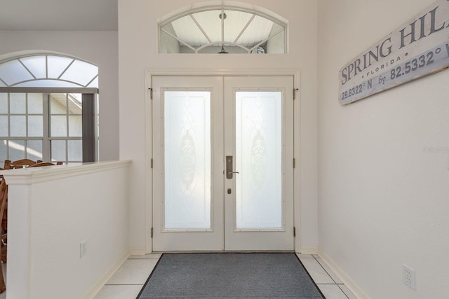 6129 Schalekamp Dr, Spring Hill, FL 34609 - entryway featuring french doors, light tile patterned floors, and baseboards
