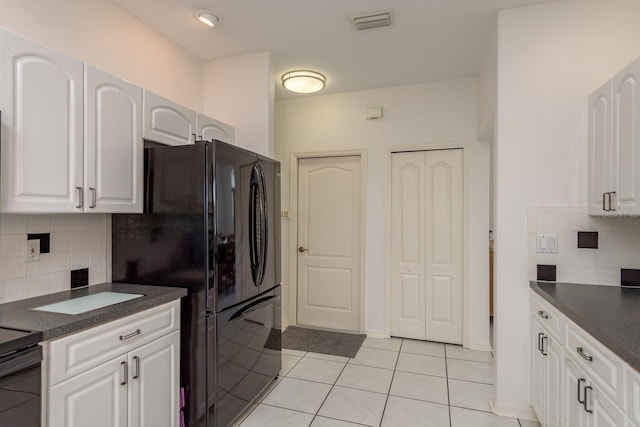 6129 Schalekamp Dr, Spring Hill, FL 34609 - kitchen with dark countertops, decorative backsplash, white cabinets, and light tile patterned floors