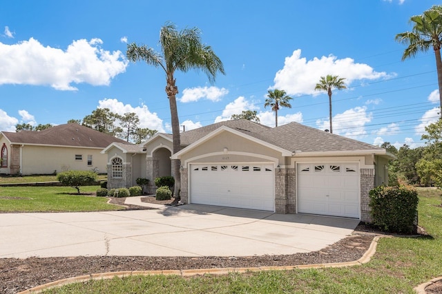 6129 Schalekamp Dr, Spring Hill, FL 34609 - ranch-style house with an attached garage, concrete driveway, brick siding, a front lawn, and stucco siding