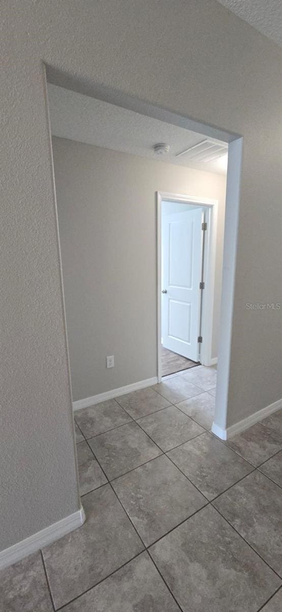 hall with tile patterned floors and baseboards