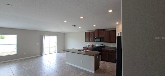 kitchen with black appliances, a sink, recessed lighting, light tile patterned flooring, and an island with sink
