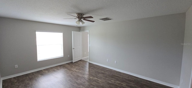 spare room featuring a ceiling fan, dark wood-style floors, a textured ceiling, and baseboards