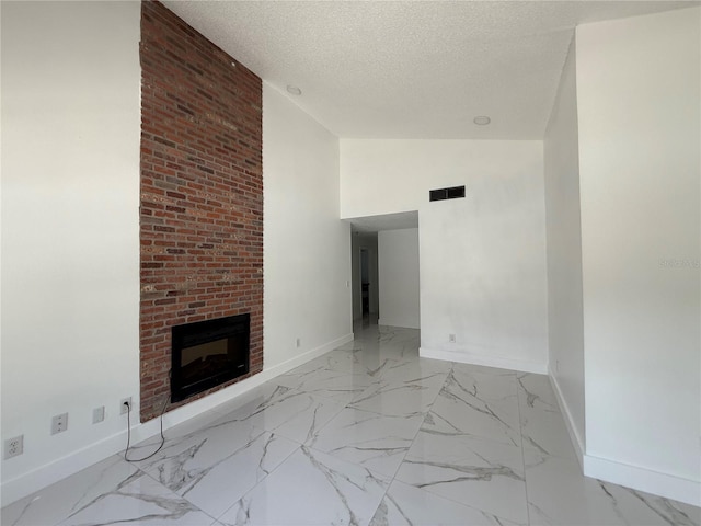 unfurnished living room featuring baseboards, a fireplace, a textured ceiling, lofted ceiling, and light marble finish flooring