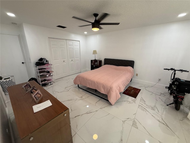 bedroom with marble look tile flooring, recessed lighting, a closet, a textured ceiling, and baseboards