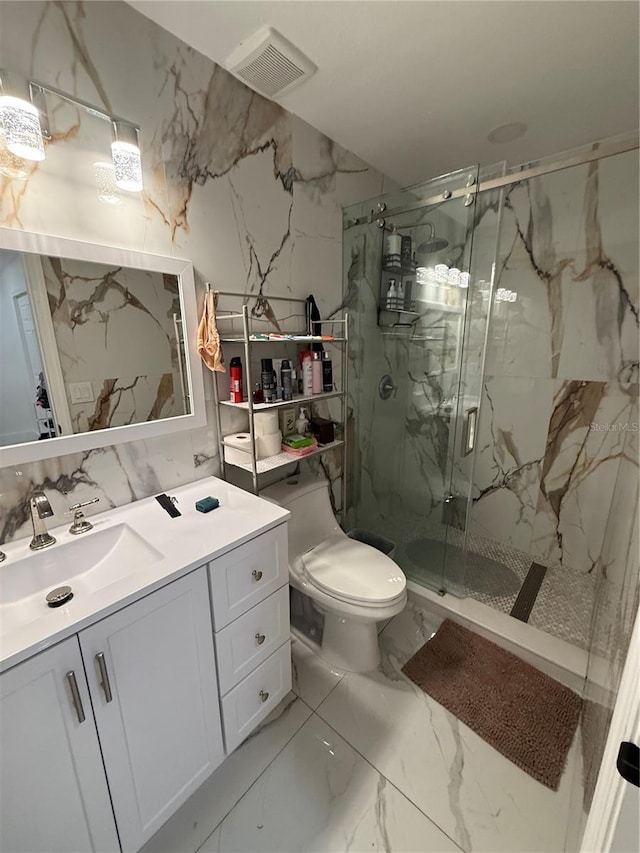 full bathroom featuring marble finish floors, toilet, a marble finish shower, and vanity